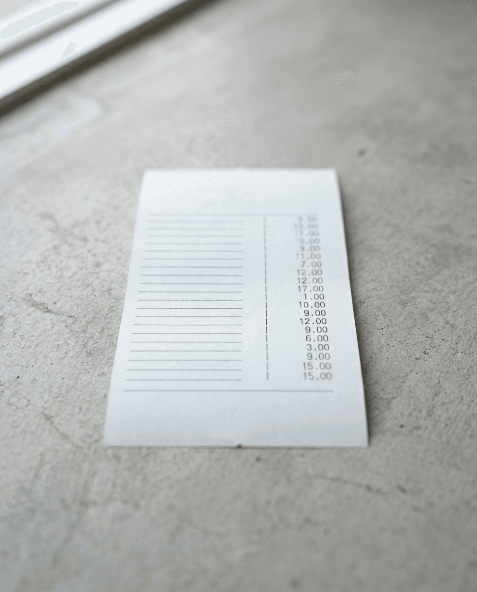 A printed receipt on a desk in soft morning light, showing a filled trade beside a ghost print of one that slipped away
